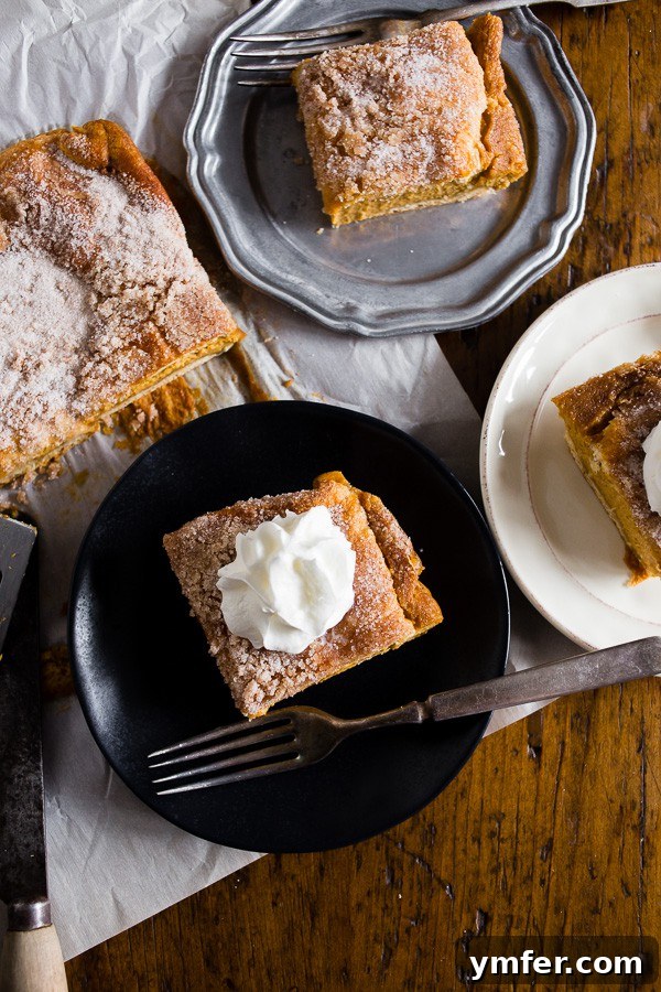 Autumn Churro Pumpkin Cheesecake Dream Bars 5 A pumpkin churro cheesecake bar on a plate with a fork, ready to be eaten.