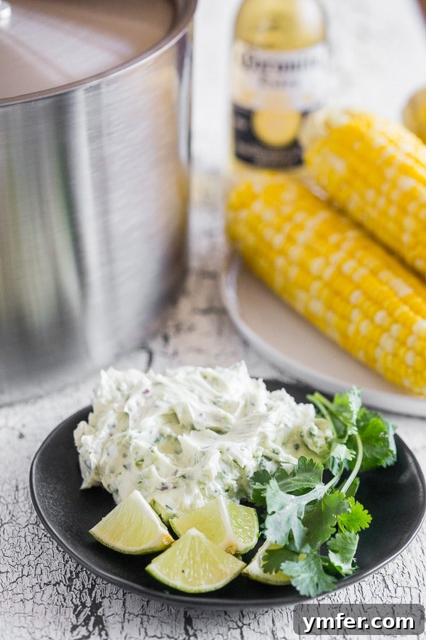 Bira Buharında Mısır Keyfi 3 Beer Steamed Corn on the Cob in the background with honey cilantro butter on a plate. The golden corn cobs are perfectly cooked, waiting to be slathered.