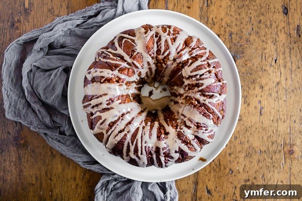 Cozy Autumn Apple Spice Monkey Bread 3 Pumpkin Spice Apple Monkey Bread on a white plate set on a rustic wooden table
