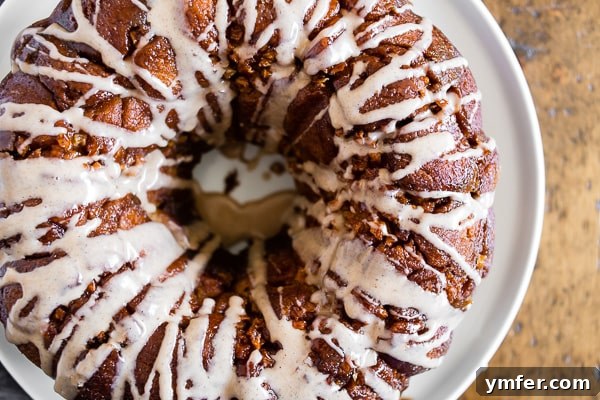 Cozy Autumn Apple Spice Monkey Bread 5 Close-up of a slice of Pumpkin Spice Apple Monkey Bread topped with a sweet pumpkin spice glaze