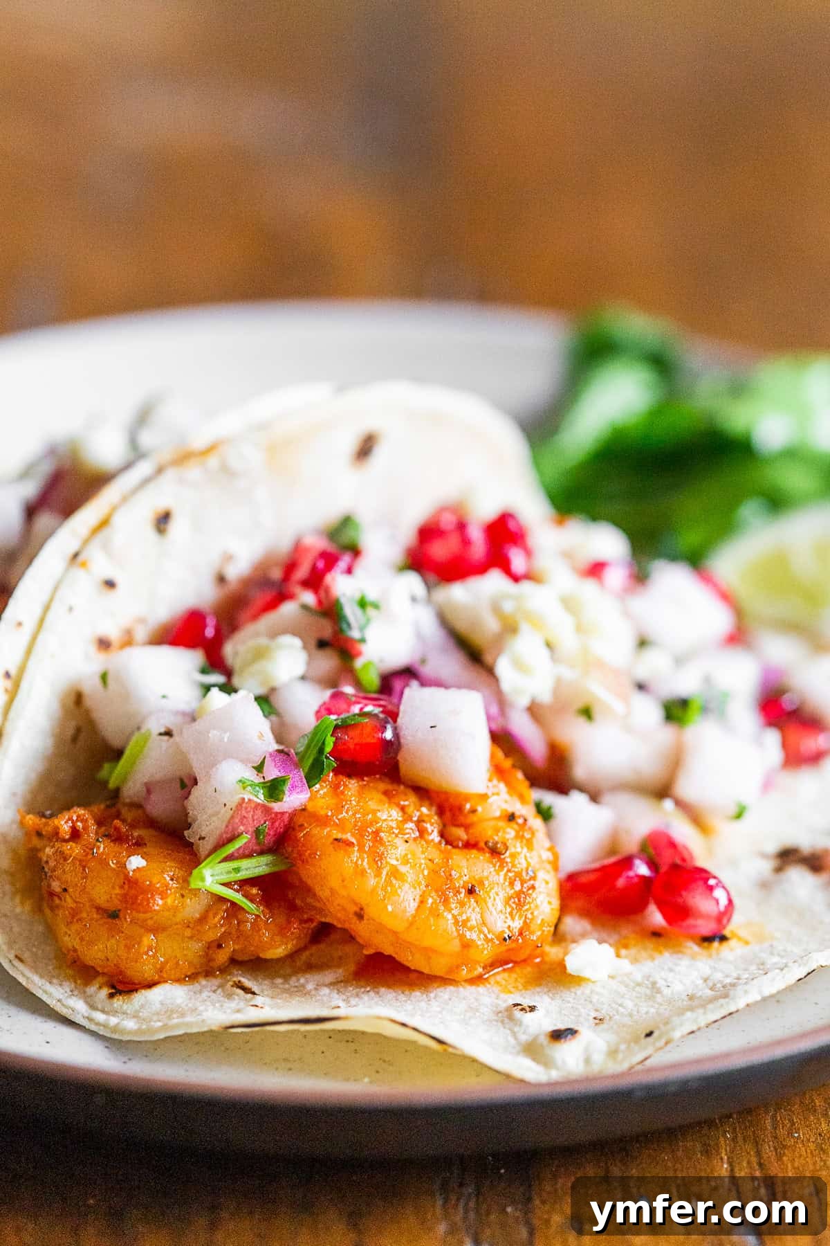 Gourmet Shrimp Tacos with Bright Apple Pomegranate Salsa 4 A single shrimp taco showcasing the vibrant apple pomegranate salsa and tender Cajun shrimp, ready to be enjoyed.