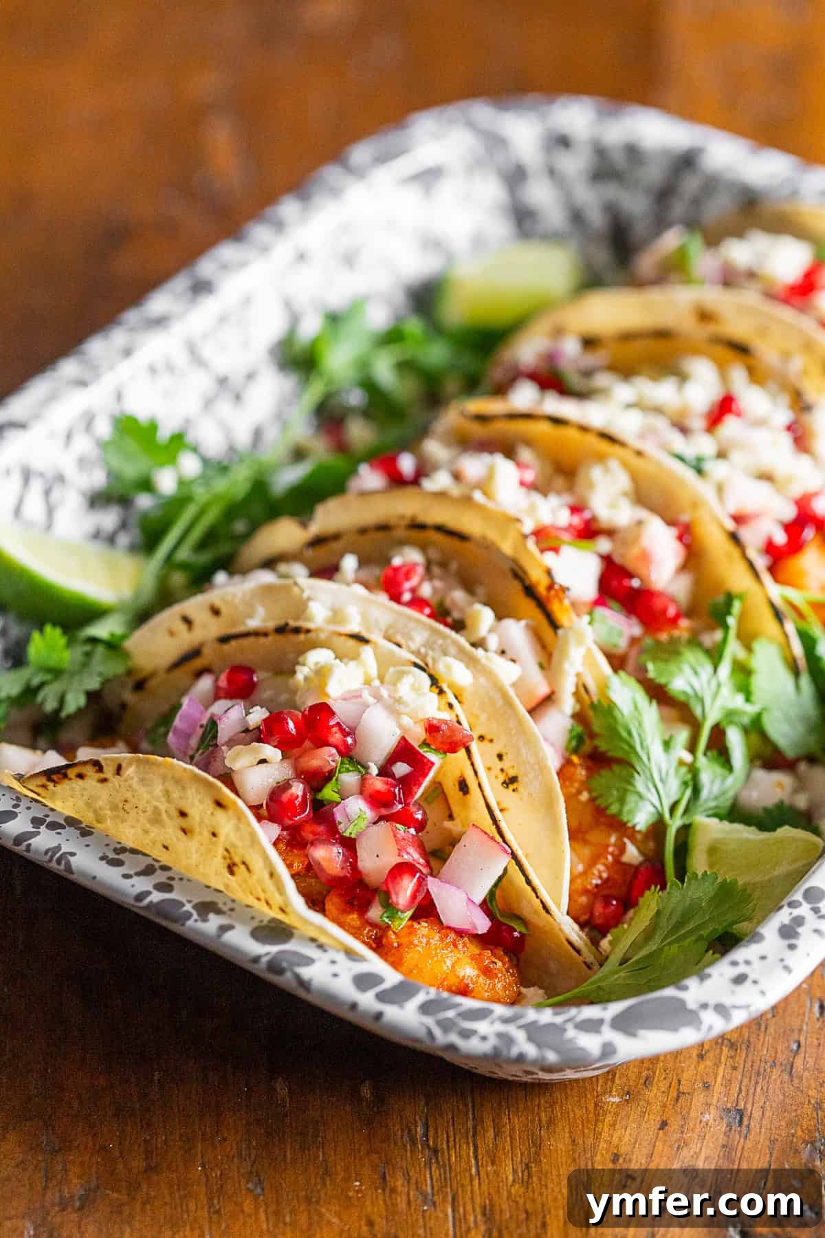 Gourmet Shrimp Tacos with Bright Apple Pomegranate Salsa 5 A visually appealing shot of shrimp tacos, beautifully topped with a colorful fruit salsa and crumbled Cotija cheese.