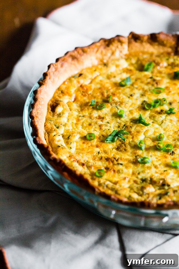 Rustic Bacon Onion Herb Quiche 3 A slice of Bacon Onion Herb Quiche topped with chopped green onions, revealing the rich filling.
