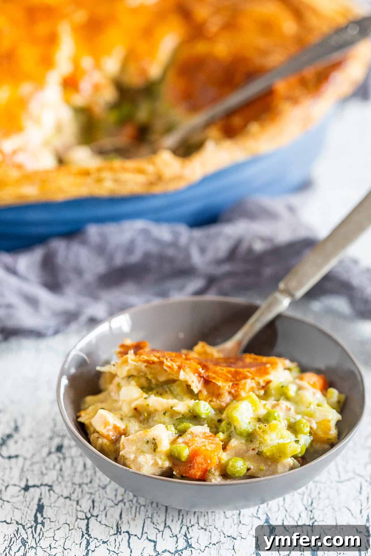 Golden Puff Pastry Turkey Pot Pie 4 A hearty serving of puff pastry turkey pot pie scooped into a white bowl, showing the rich filling and flaky crust.