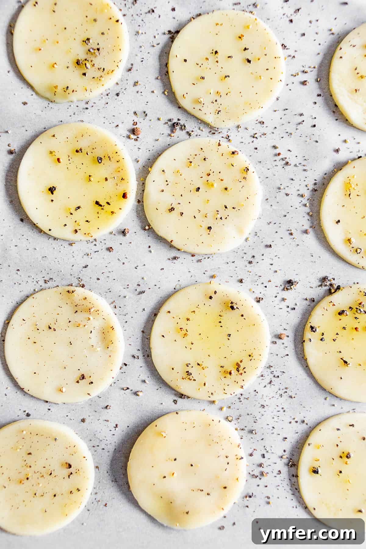 Tangy Chevre Clouds 4 An uncooked round pie crust on a baking sheet, before being transformed into a crispy cracker.