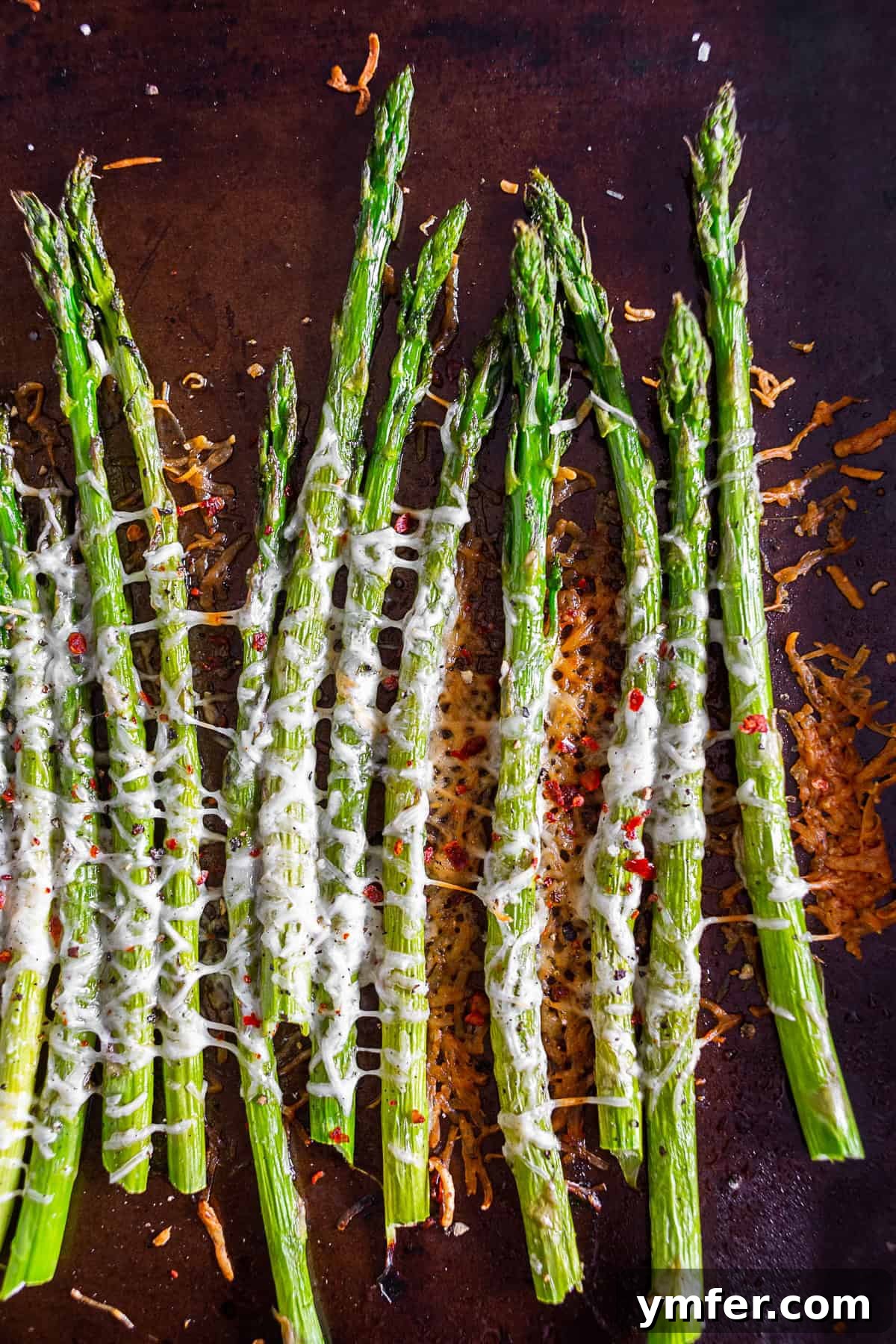 Crispy Parmesan Roasted Asparagus 2 Parmesan Roasted Asparagus on a sheet pan, ready to be served, showing its golden-brown cheese and vibrant green color.