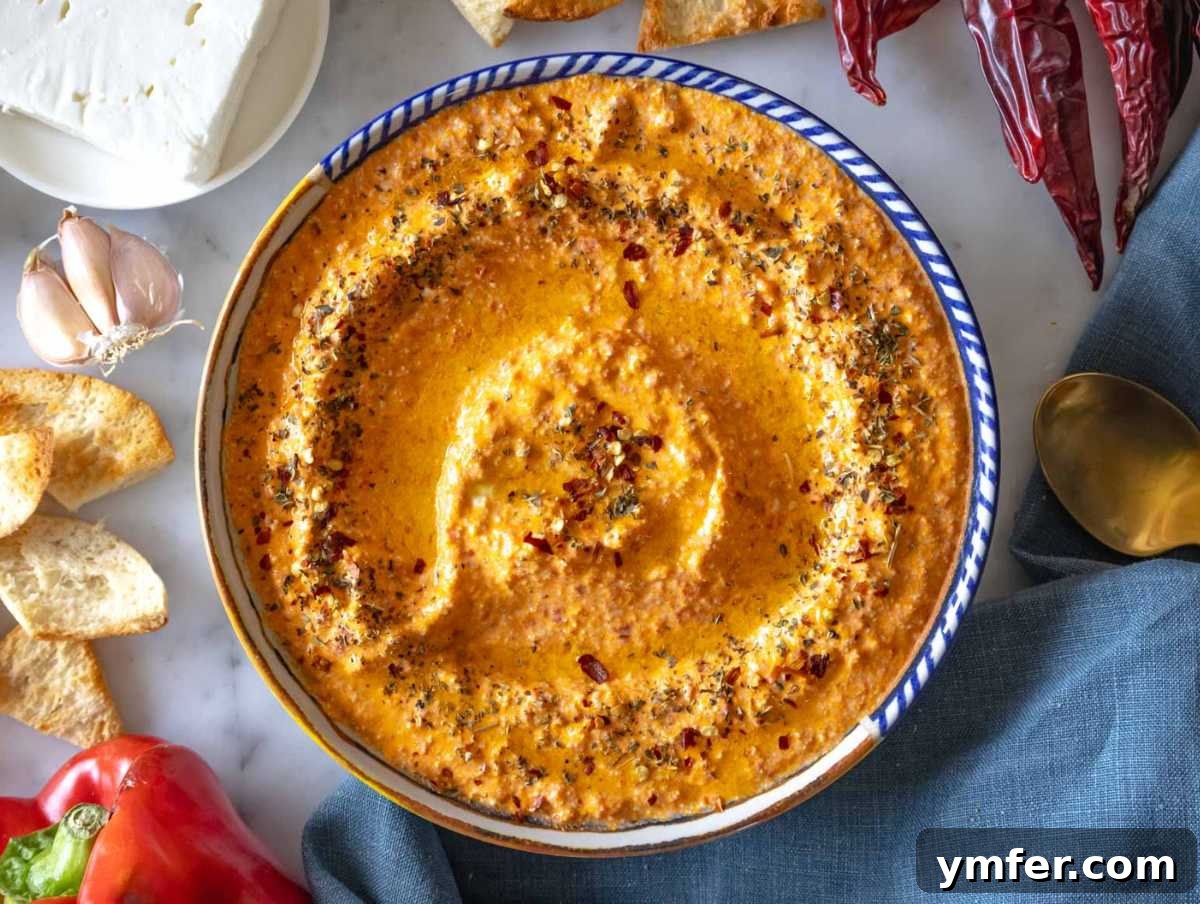 Fiery Feta Delight 6 A beautiful serving bowl filled with Greek spicy feta dip (Tirokafteri), surrounded by crispy pita chips, ready to be enjoyed.