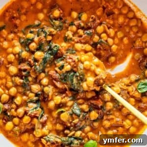 Soulmate Chickpeas 8 A close-up of marry me chickpeas with a spoon, showing the creamy texture and spinach.