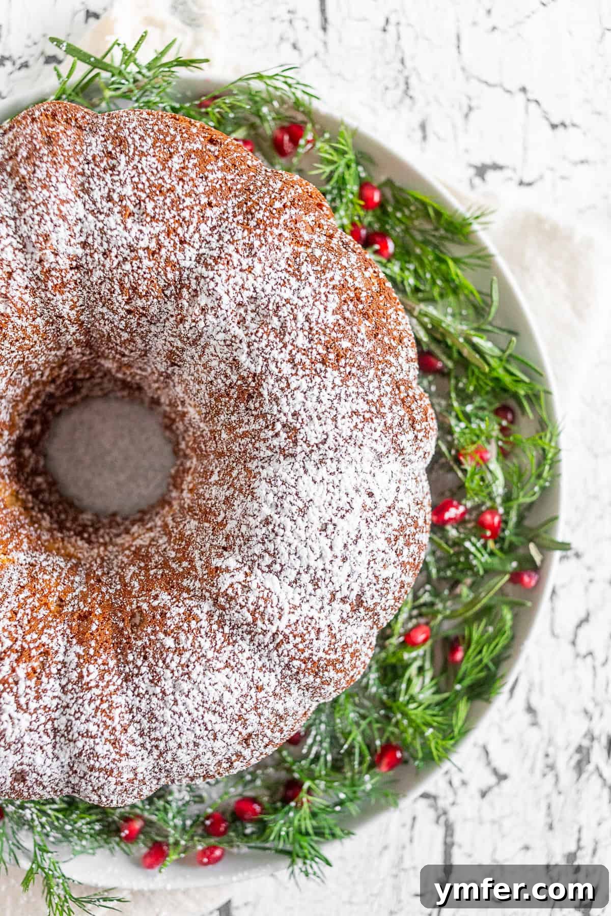 Elegant Sherry Bundt Cake 2 Golden brown Cream Sherry bundt cake, lightly dusted with powdered sugar, sitting elegantly on a white cake plate, ready to be served for the holidays.