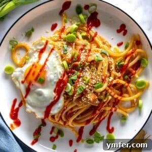 Umami Gold 8 Miso pasta with a fried egg and sriracha sauce, presented in a bowl ready for serving.