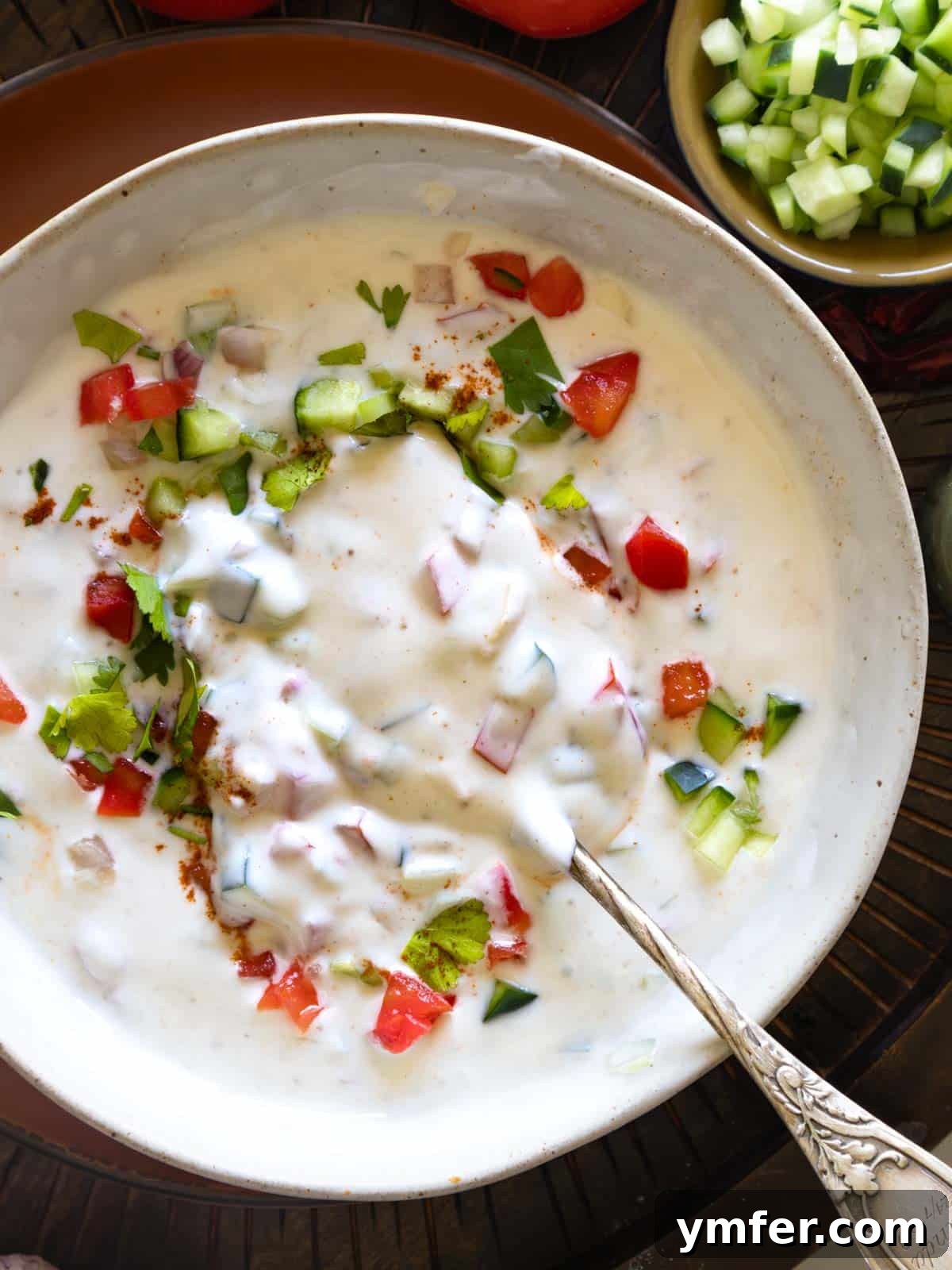 Refreshing Raita 4 Close-up of Raita in a bowl with a spoon, ready to be served.