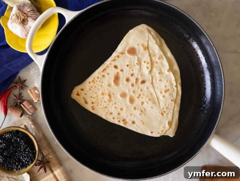 Flaky Stuffed Paratha Perfection 16 Paratha cooking on a cast-iron skillet.
