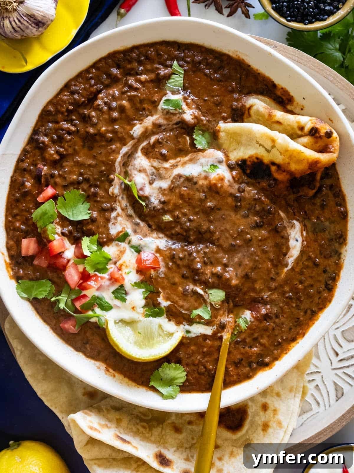 Dal Makhani Black Lentil Curry 2 Creamy Dal Makhani served with warm flatbreads, garnished with fresh cilantro.
