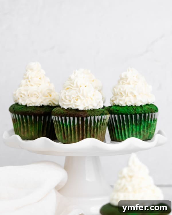 Emerald Velvet Cupcakes 3 Assortment of green velvet cupcakes artfully arranged on a pristine white cake plate.