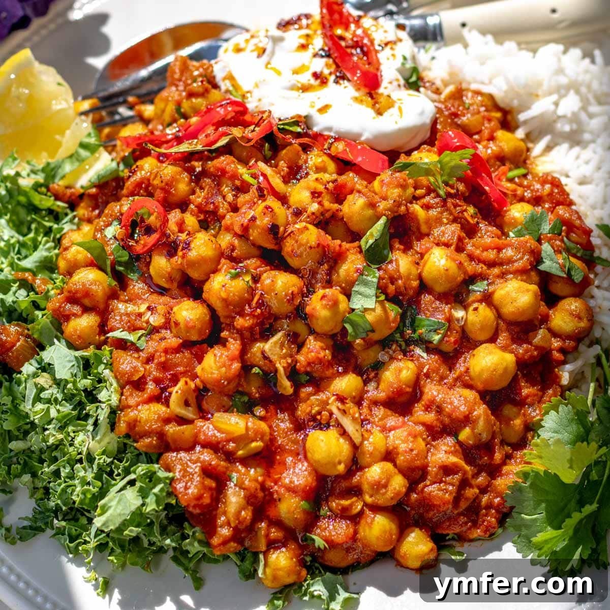 25 High Fiber Power Foods 23 chana masala with kale and a dollop of yogurt on a plate