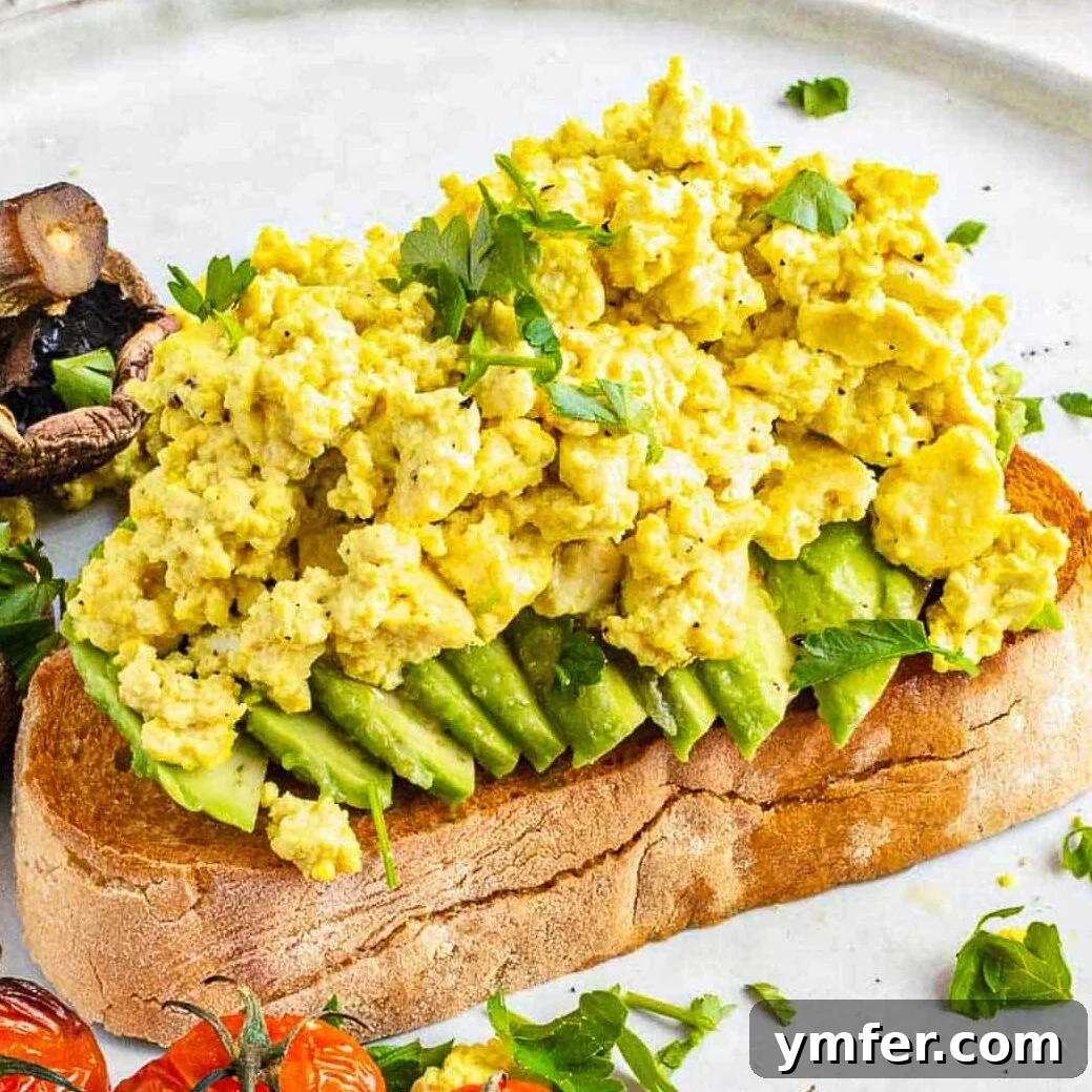 A delicious tofu scramble served on fresh bread with an assortment of vibrant vegetables.