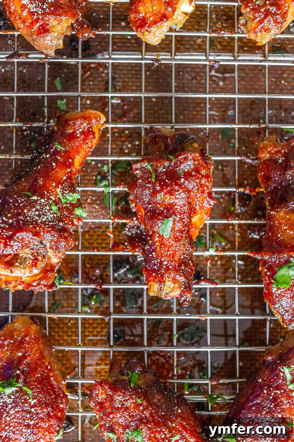 Sticky Apple Butter Wings 3 Close-up view of a single, perfectly crispy baked chicken wing, glistening with a delicious glaze, ready to be served.