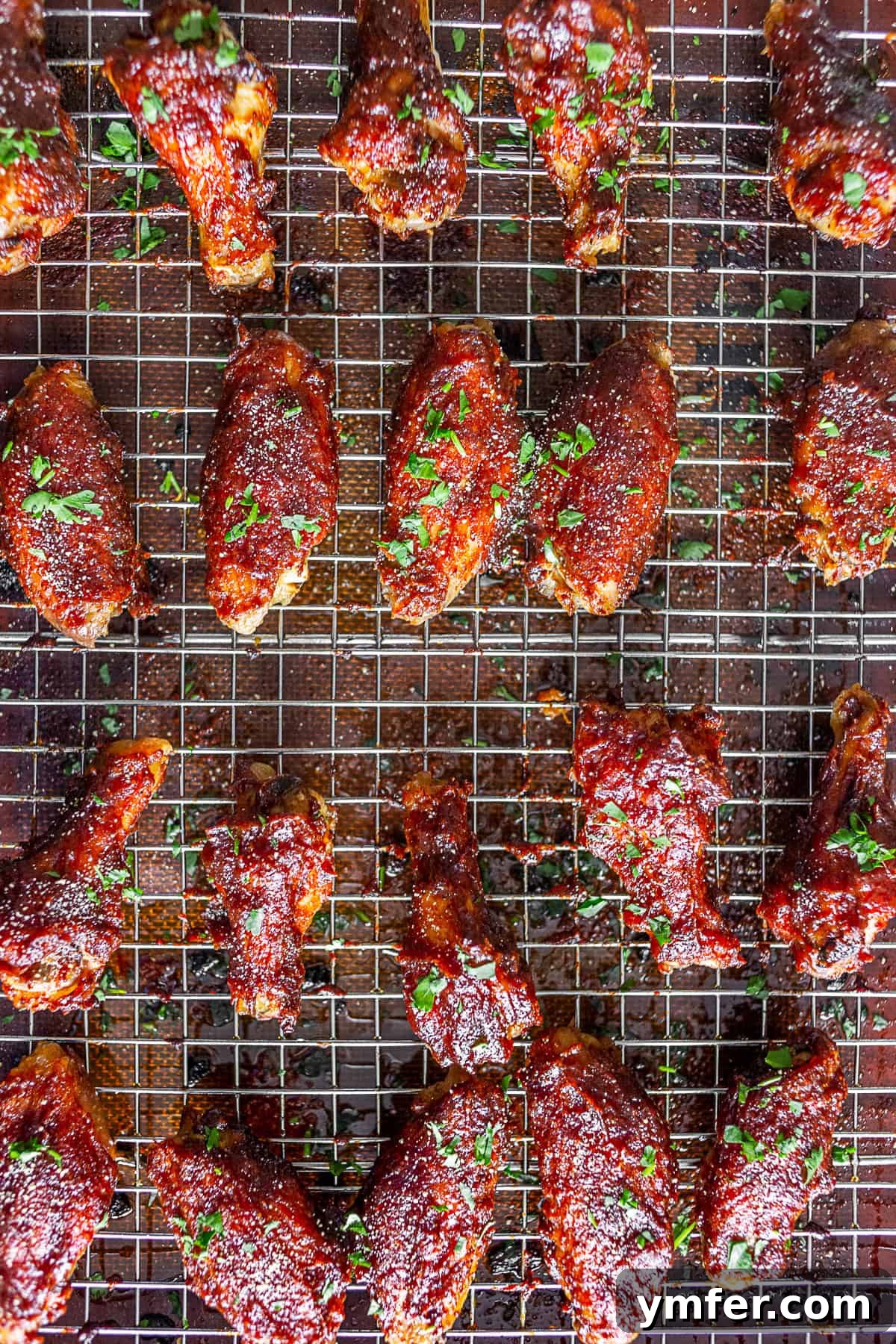 Sticky Apple Butter Wings 4 Crispy chicken wings, generously coated in a rich glaze, laid out on a baking tray with a grilling rack, ready for serving.