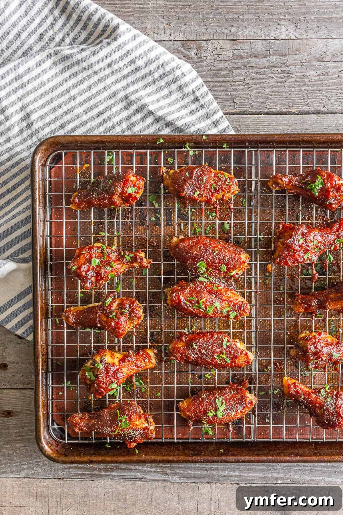 Sticky Apple Butter Wings 5 Apple butter chicken wings cooking on a wire rack placed over a baking tray, ensuring maximum crispiness.
