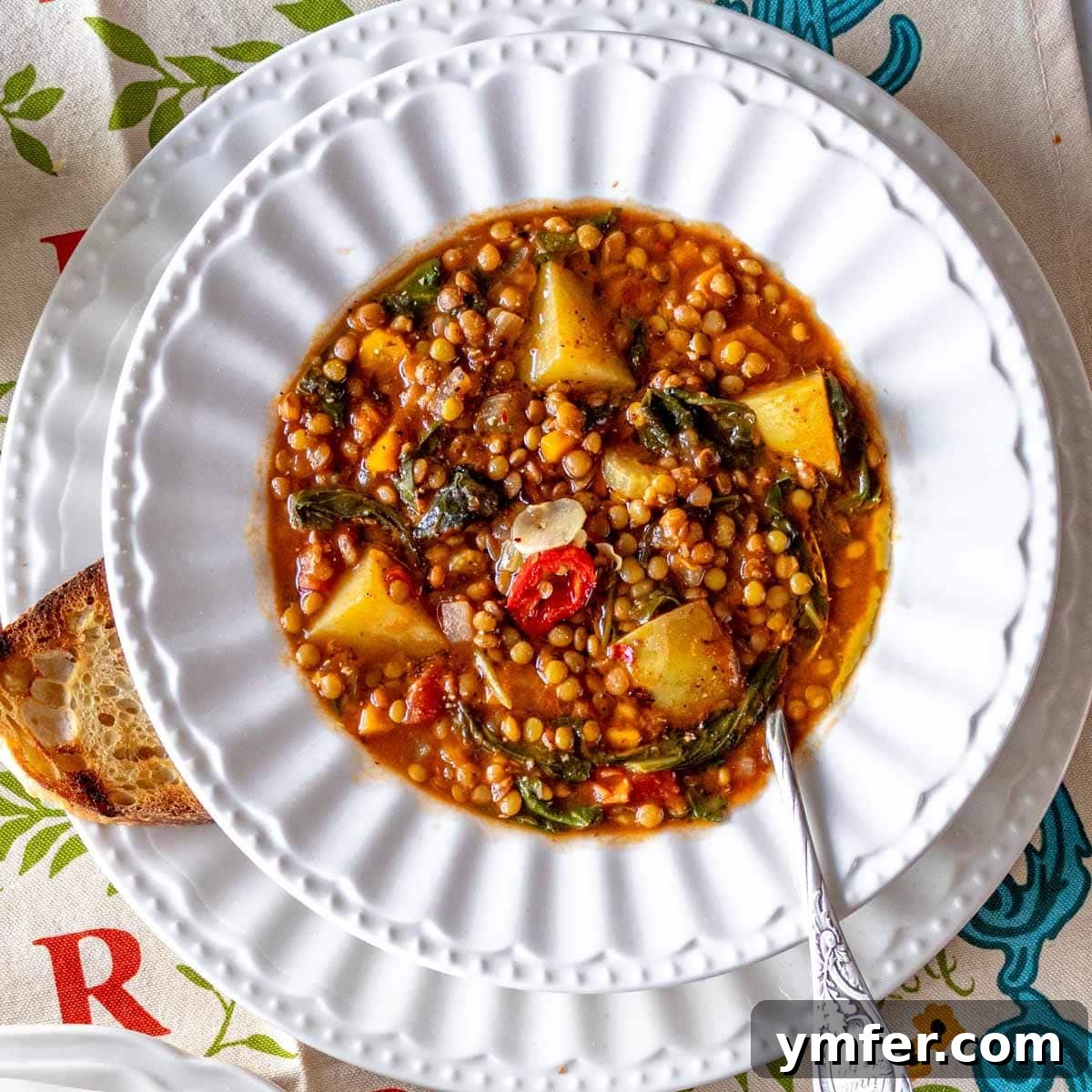 Heart-Smart Meals 4 easy lentil soup in a white bowl with bread and a spoon. A comforting and wholesome meal.