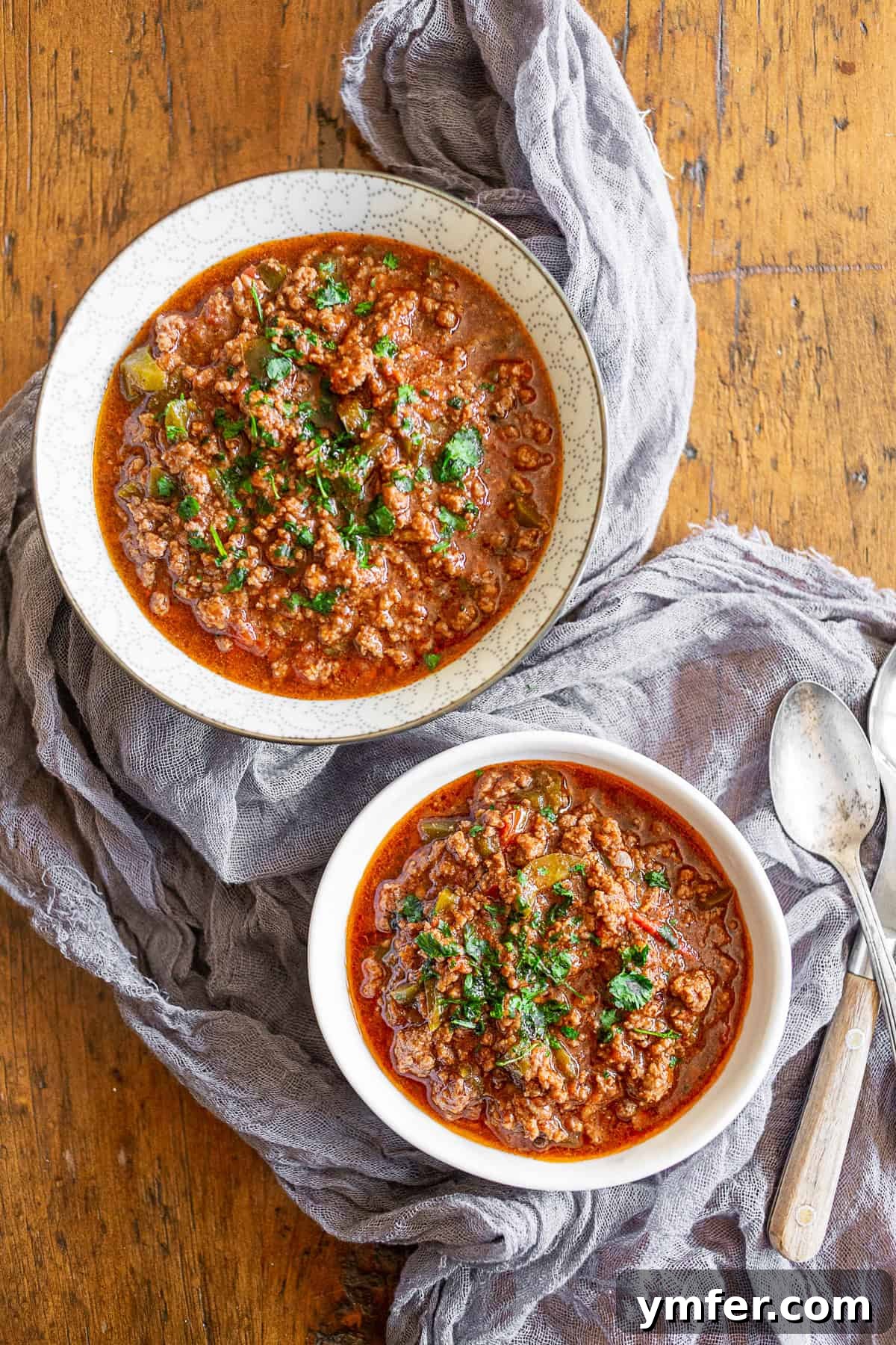 Sichuan Chili Pork Mince 2 Two bowls of ground pork Chinese chili, garnished with fresh cilantro.
