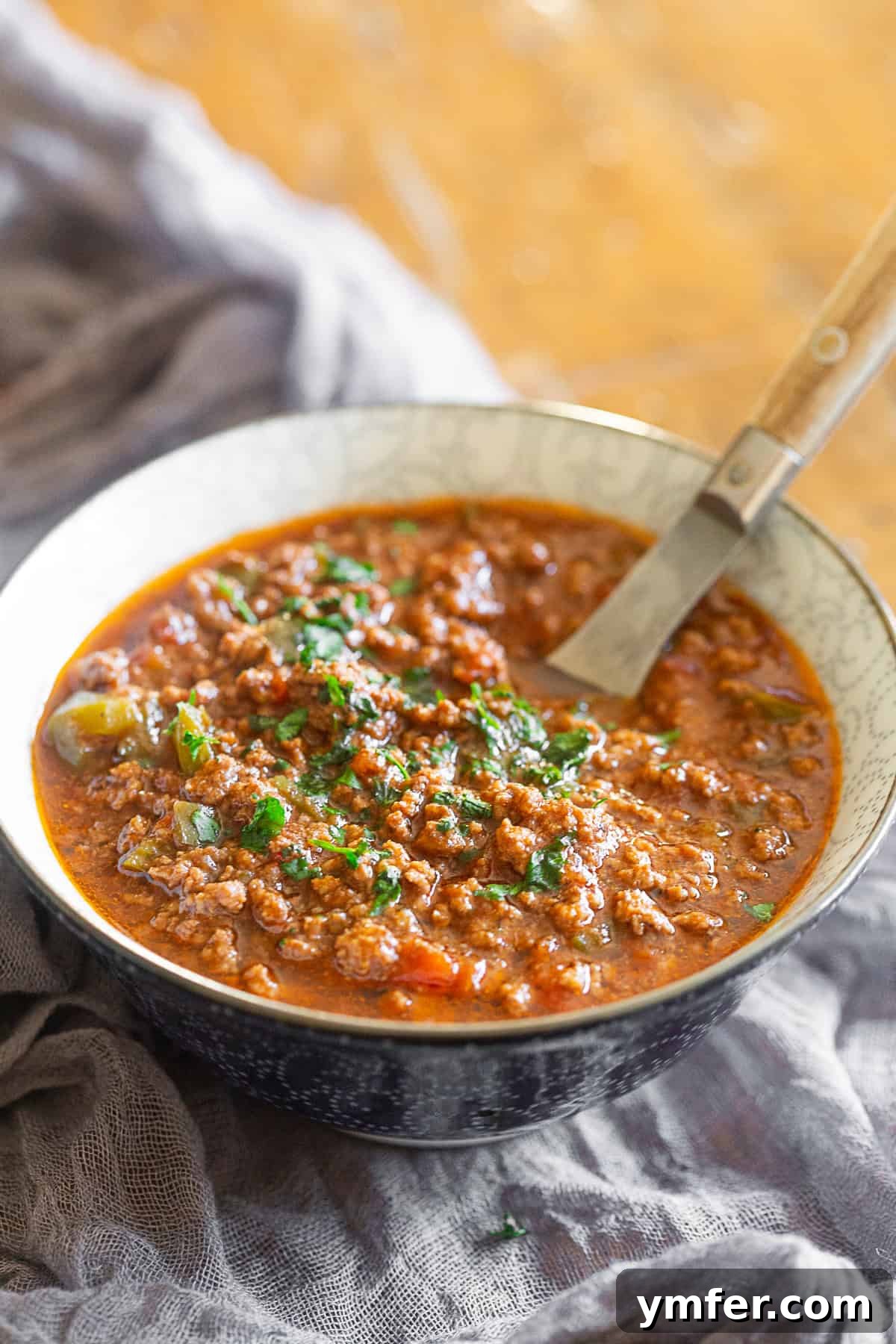 Sichuan Chili Pork Mince 5 Ground Pork Chinese Chili in a bowl with a spoon, garnished with cilantro.