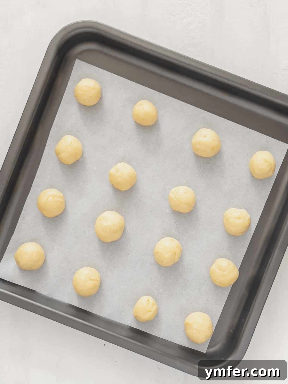 Castagnole Italian Carnival Fritters 12 Shaped Castagnole dough balls arranged neatly on a baking tray, ready for the oven