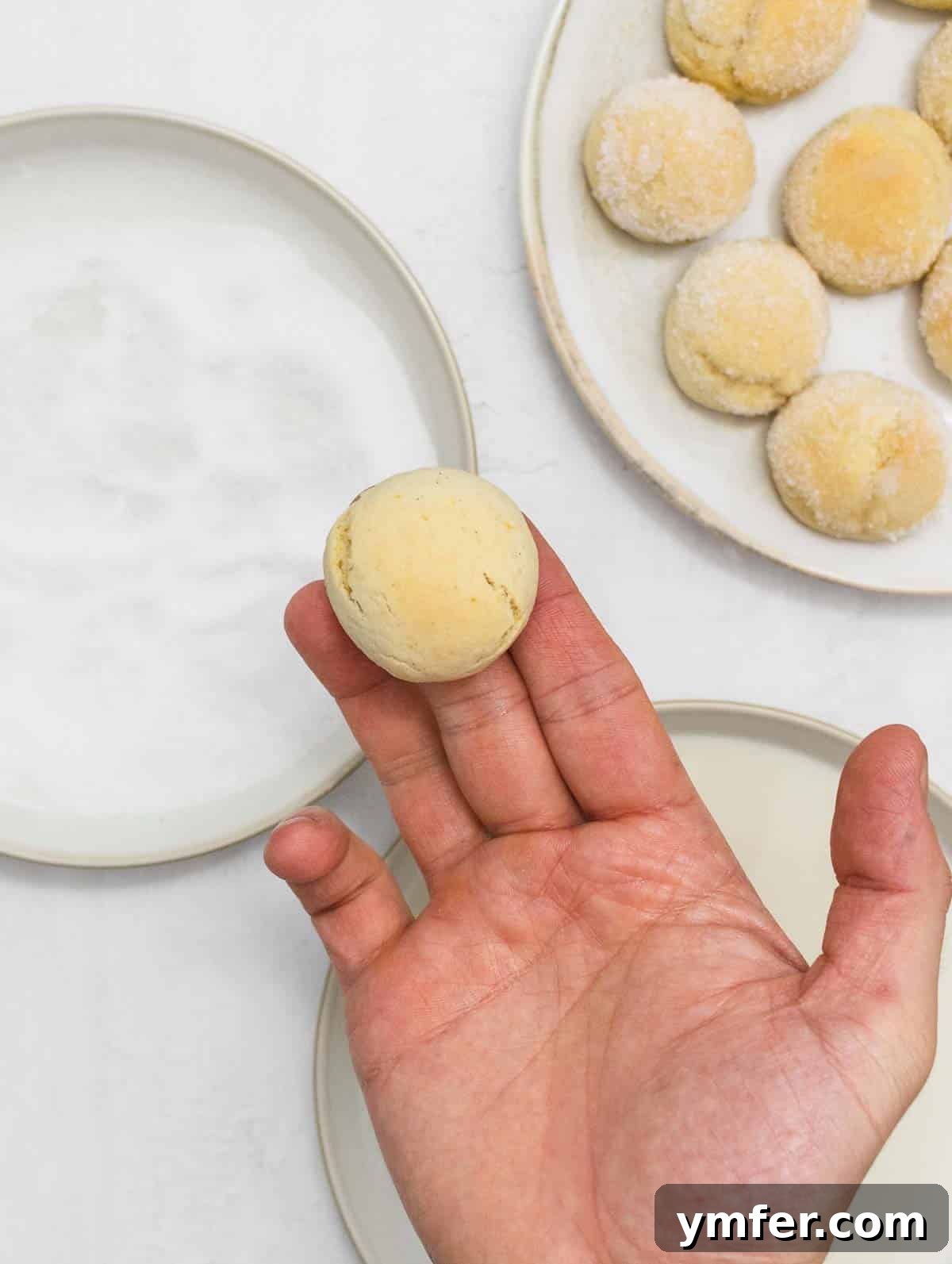Castagnole Italian Carnival Fritters 14 Picking up a warm, oven-baked Castagnola, ready for its sweet coating