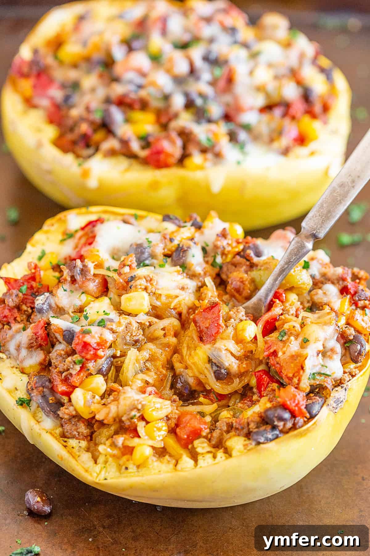 Zesty Southwest Taco Spaghetti Squash Boats 3 A serving of Southwest taco stuffed spaghetti squash with a fork, showing the rich filling and stringy squash.