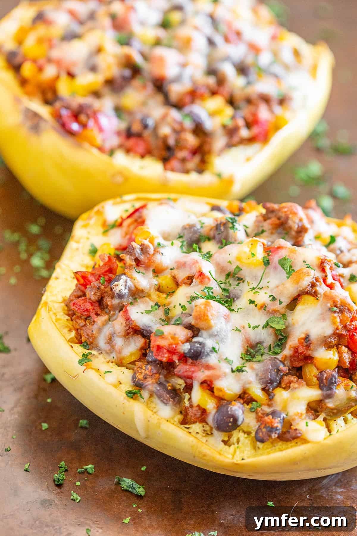 Zesty Southwest Taco Spaghetti Squash Boats 4 Close-up of Southwest taco stuffed spaghetti squash on a sheet pan, topped generously with melted pepper jack cheese.
