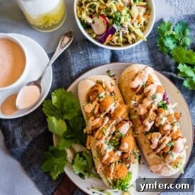 This Asian shrimp po boy sandwich is packed full of flavor and perfect for the busy weeknight meal planning. First, you take a crusty roll and pack it full of a crunchy Asian flavored broccoli slaw, top with crispy baked shrimp and drizzle with spicy Sriracha mayo. You'll love this sandwich!