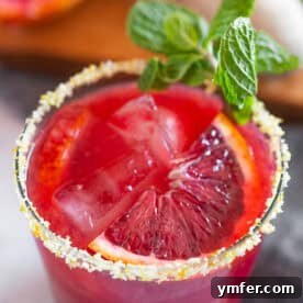Blood Orange Margarita with a salt citrus rim, and a blood orange slice garnish.