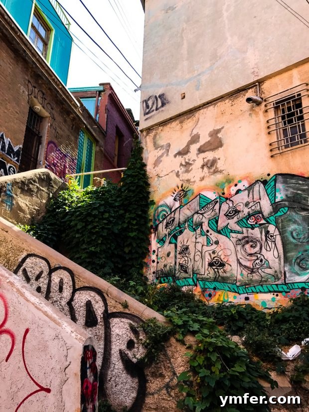 Valparaiso Street Art: Explore Chile's Open-Air Gallery 3 Vibrant street art depicting abstract shapes and figures on a wall in Valparaiso, showcasing the city's dynamic artistic landscape.