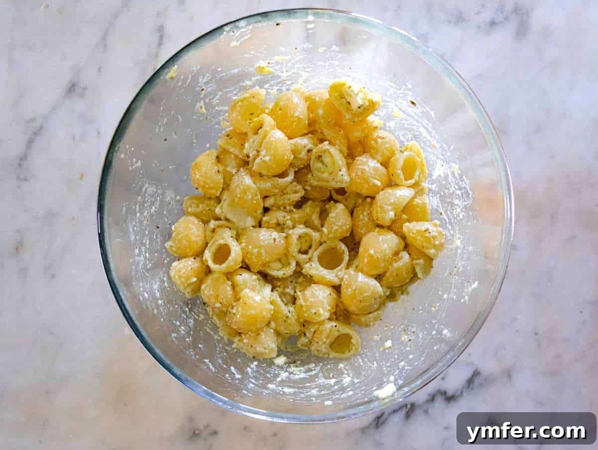 Summer Peach & Creamy Feta Delight 7 Mixing warm cooked pasta into the creamy feta dressing.