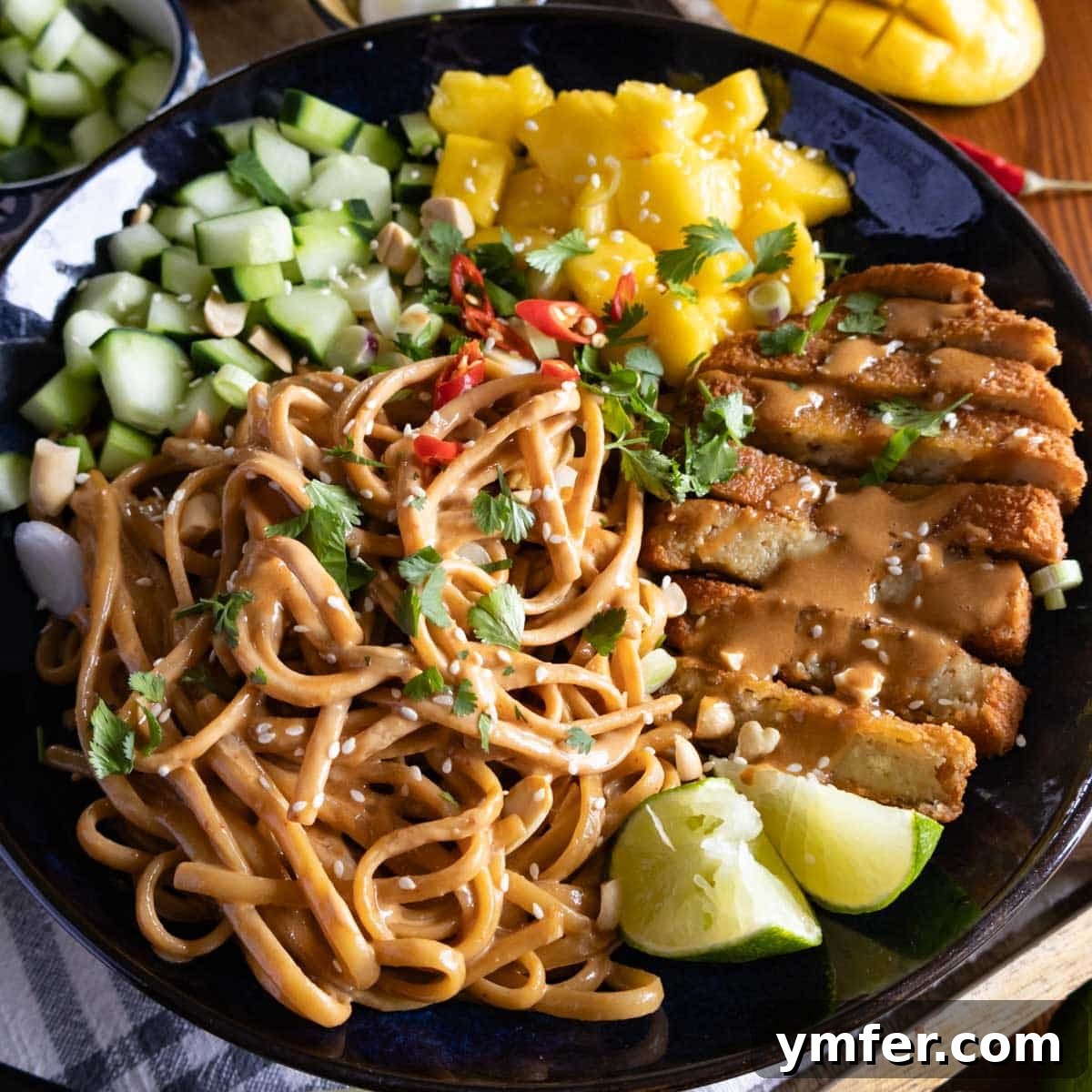 Beat the Heat 30 No-Bake Dinners 16 Sesame noodles in a dark bowl topped with grilled tofu, fresh mango, cucumber, and lime for a refreshing cold dinner.