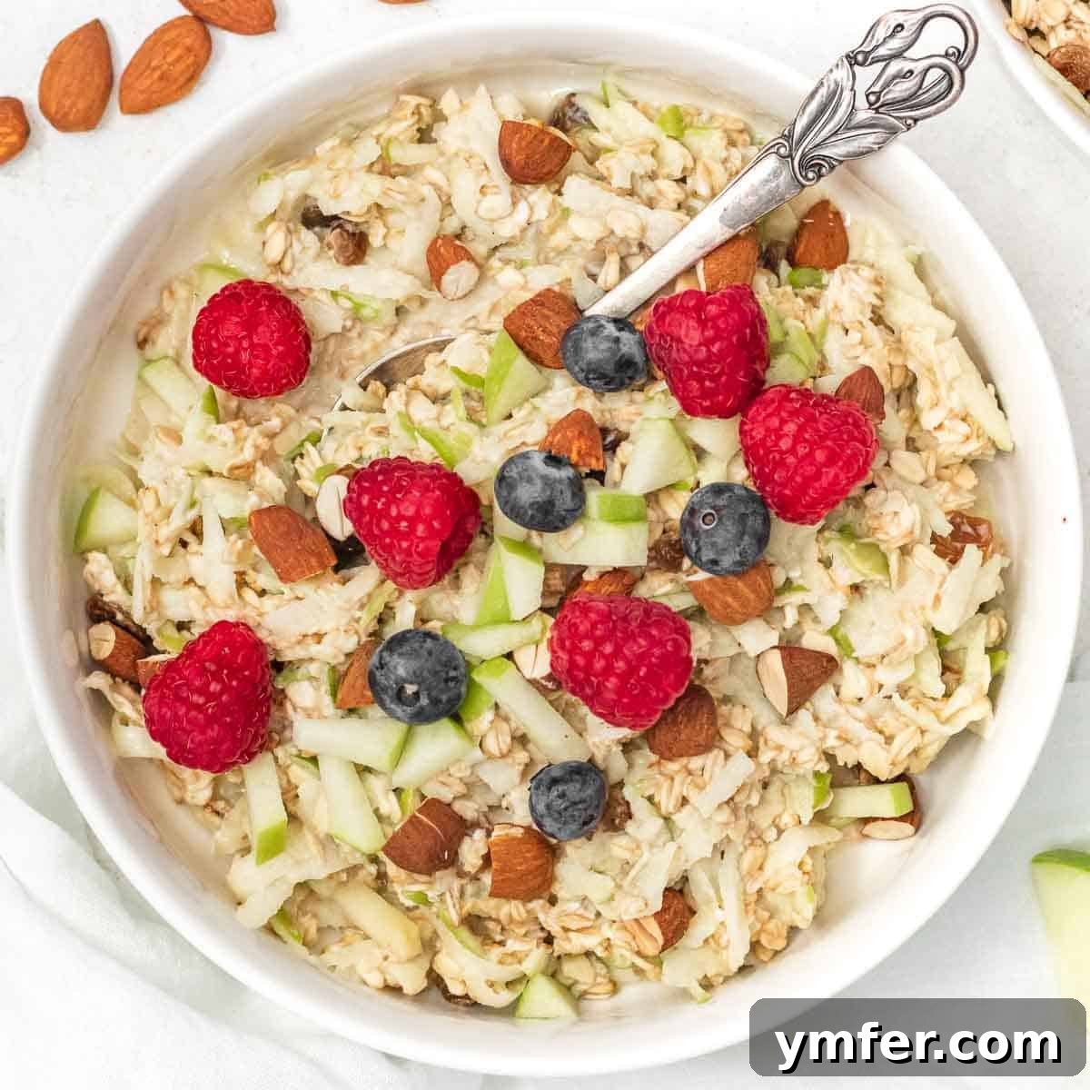 Mediterranean Diet for Vibrant Health 6 A beautiful bowl of Bircher muesli garnished with fresh, ripe raspberries and blueberries, presenting a perfect, refreshing, and healthy breakfast option.