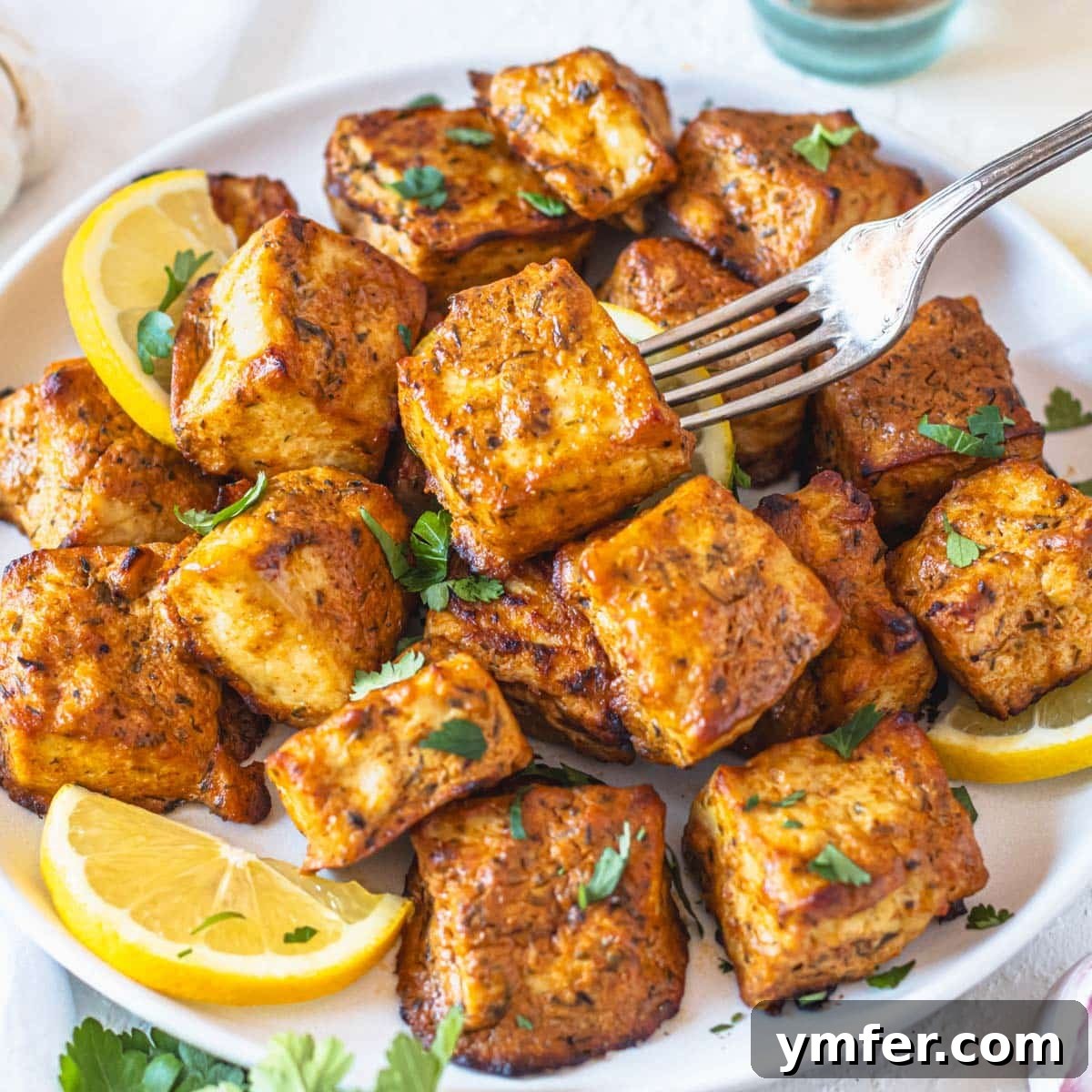 21 Greek Kitchen Classics 12 Flavorful marinated tofu skewers with lemon slices and a silver fork, highlighting the grilled texture.