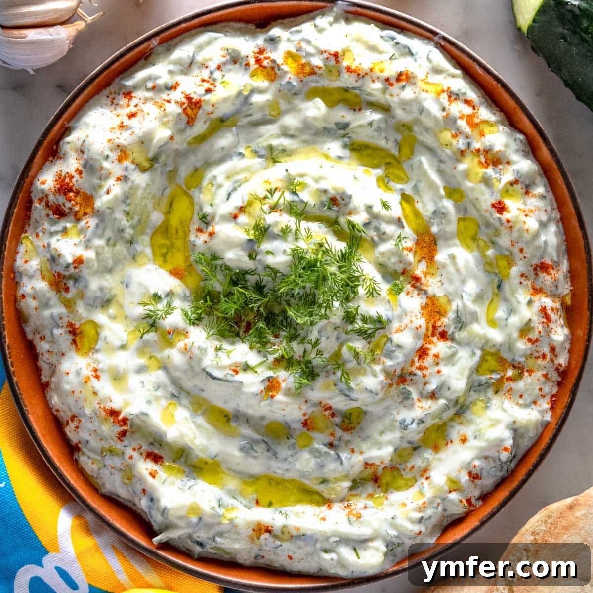 21 Greek Kitchen Classics 3 Creamy Tzatziki dip garnished with fresh dill in a white bowl, ready to serve.