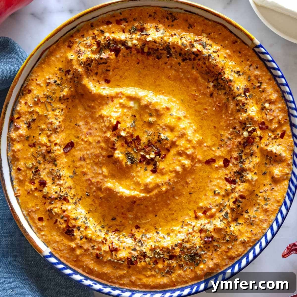 21 Greek Kitchen Classics 4 Vibrant spicy feta dip, Tirokafteri, in a bowl with a spoon, highlighting its creamy texture.