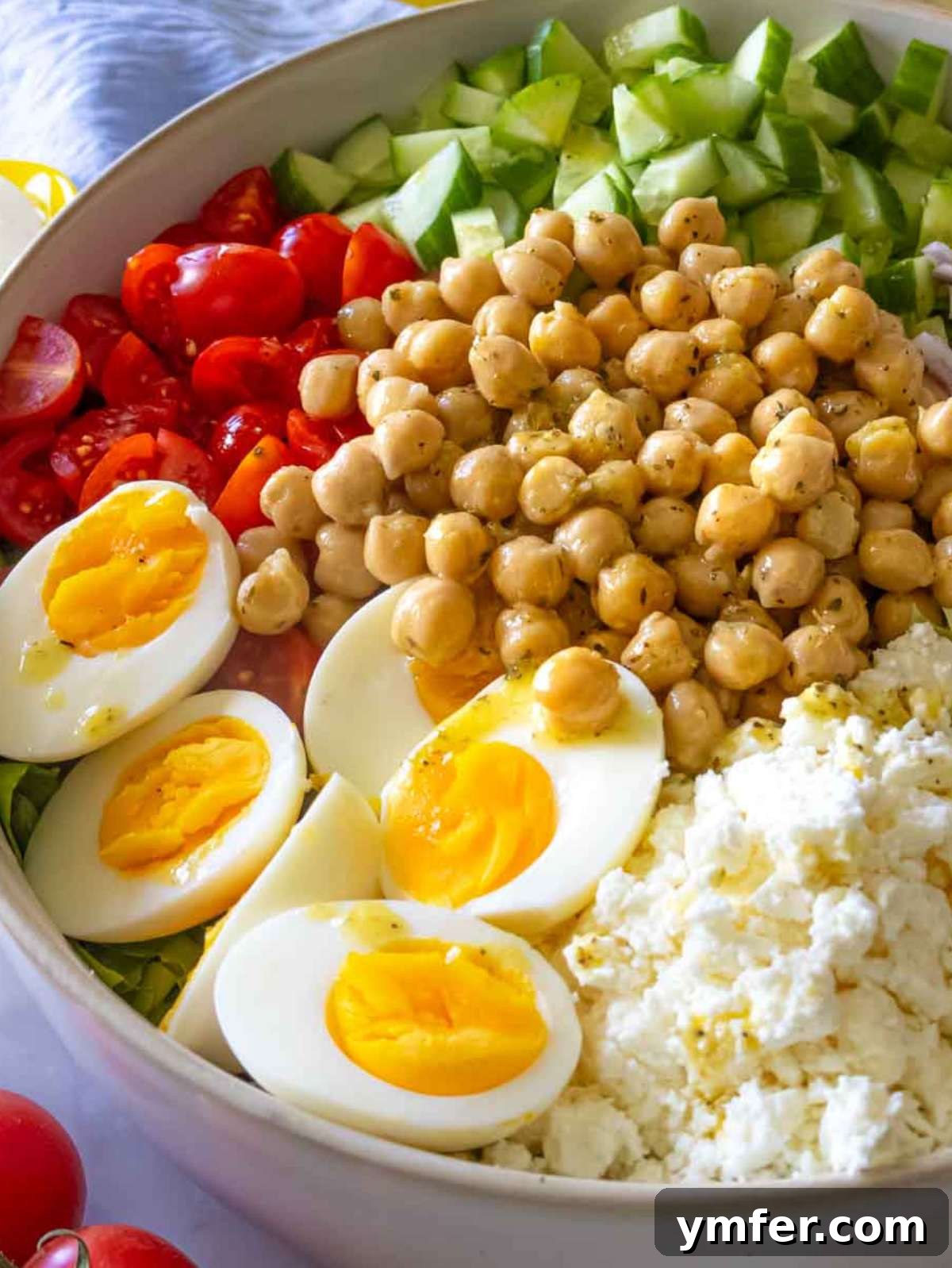 Vibrant Mediterranean Bowl 3 Close-up photograph of Mediterranean chopped salad, showcasing the appealing textures of chickpeas, crumbled feta cheese, and a medley of fresh vegetables.