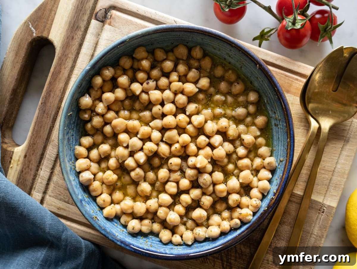 Vibrant Mediterranean Bowl 6 Step 3 - A bowl of chickpeas soaking in the vibrant lemon-oregano dressing, emphasizing the marinade step for enhanced flavor in the Mediterranean chopped salad.