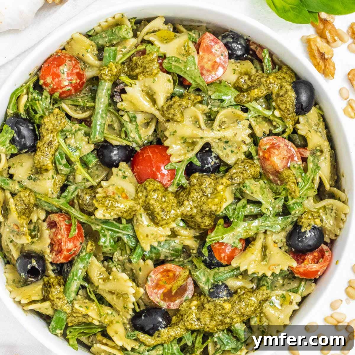 15 Effortless Pasta Salads You'll Crave All August 9 Pesto pasta salad in a bowl with tomatoes