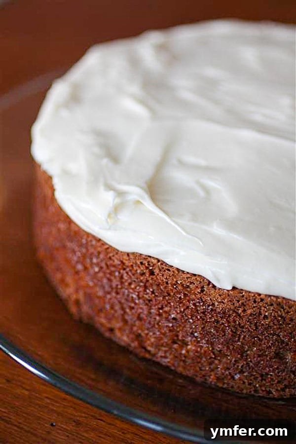 Spiced Carrot Cake with Luscious Cream Cheese Frosting 3 Slice of carrot cake with creamy cream cheese frosting on a glass plate