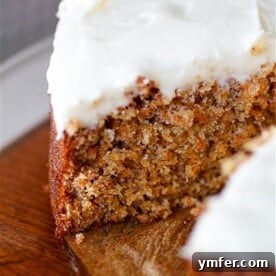 Carrot cake with creamy cream cheese frosting cut with one slice missing