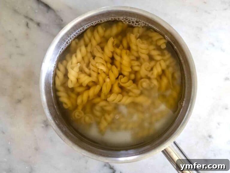 Easy Bruschetta Pasta No Cook Sauce 10 Step 2: Pasta boiling vigorously in a large pot of salted water on a stovetop, ensuring even cooking for the perfect al dente texture.