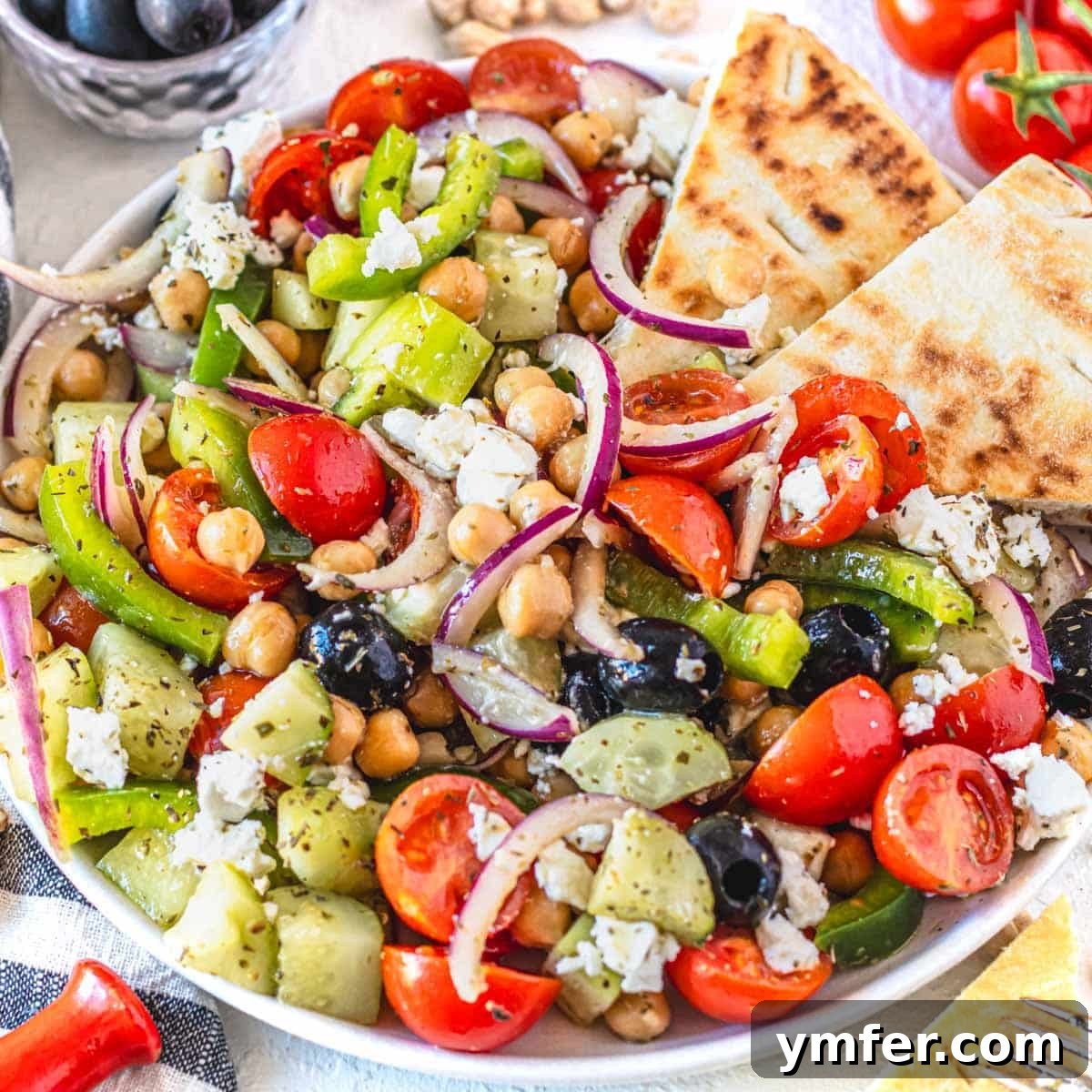 Strong & Satisfying: 21 High-Protein Salad Recipes 11 Greek chickpea salad with olives and pita bread on a plate