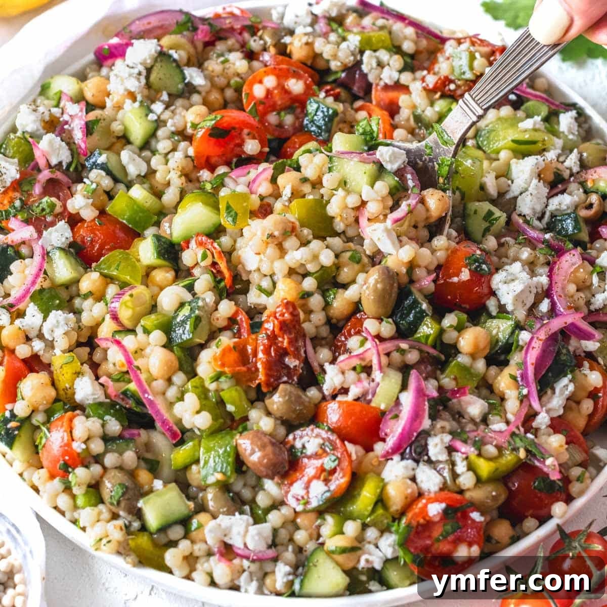 Strong & Satisfying: 21 High-Protein Salad Recipes 14 Israeli couscous with sumac onions and fresh vegetables on a plate