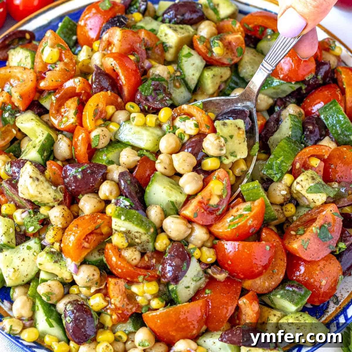 Strong & Satisfying: 21 High-Protein Salad Recipes 4 chickpea salad with hand holding a silver spoon