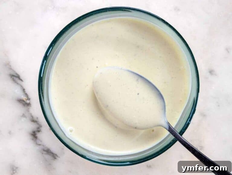 Wholesome & Creamy Greek Yogurt Coleslaw 12 Step 3 Whisking creamy Greek yogurt dressing with mustard, vinegar, and mayo in a small bowl.