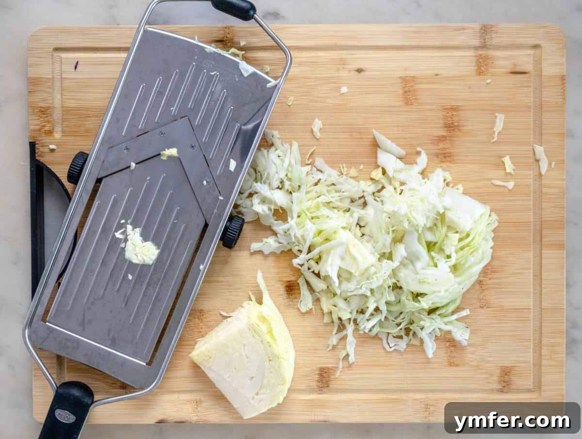 Wholesome & Creamy Greek Yogurt Coleslaw 5 Step 1: Expertly shredding vibrant green and red cabbage thinly using a mandoline slicer on a clean cutting board, ensuring uniform pieces for the coleslaw.